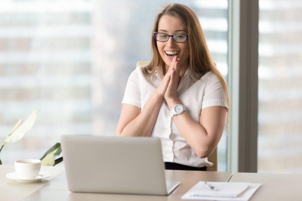 A happy businesswoman looking at her laptop