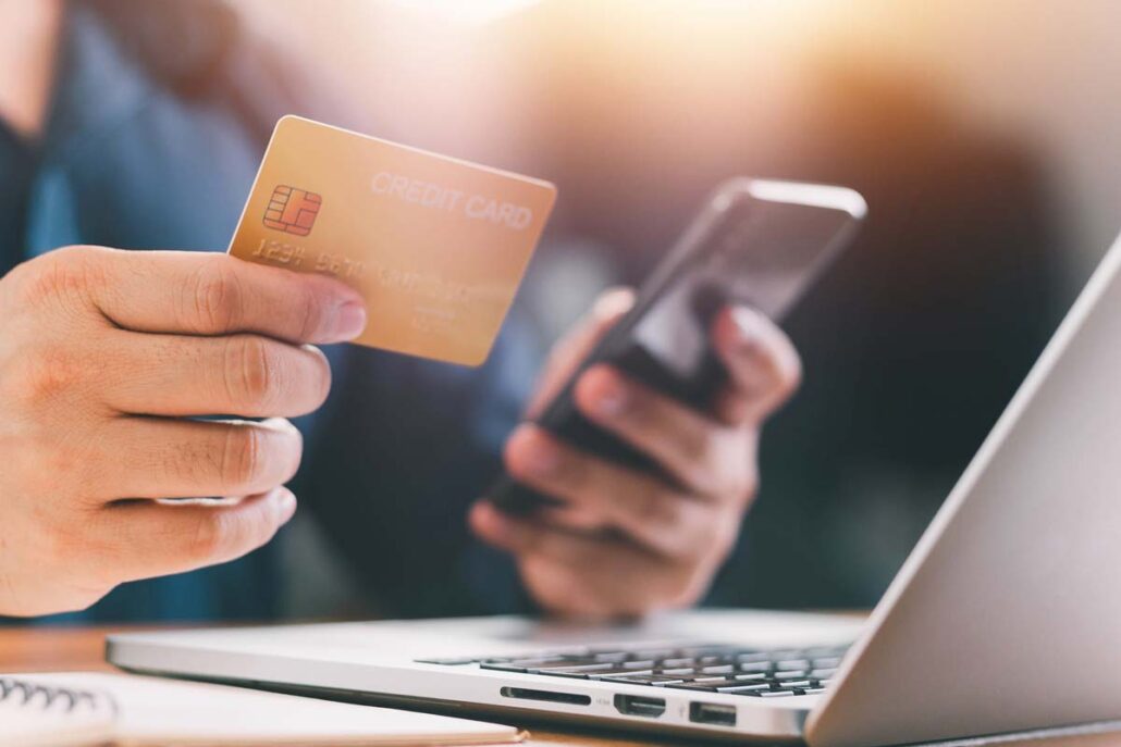 A person holding a credit card, shopping online