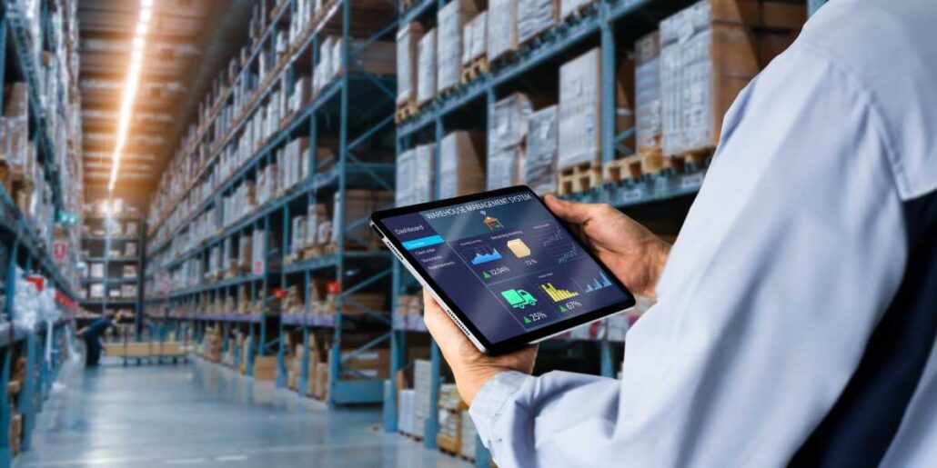 A person in a warehouse looking at inventory data on a tablet