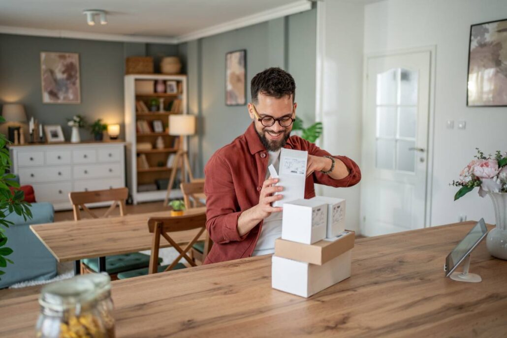 A happy person opening packages at home