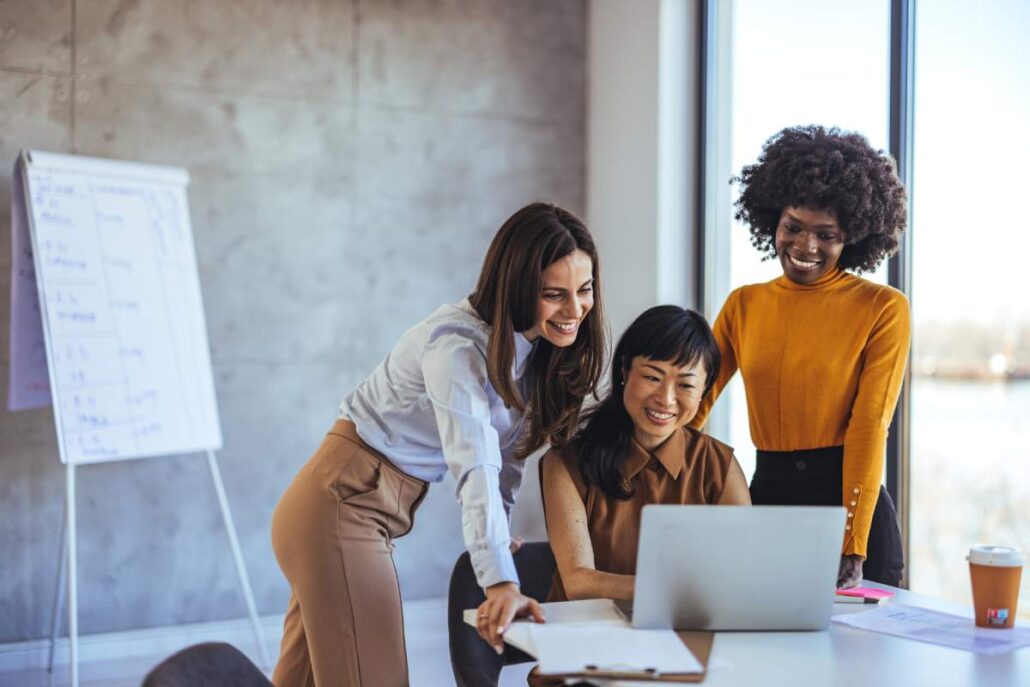 Happy women in an office on a laptop