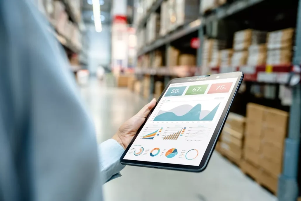 A close up of a tablet showing data and analytics in a warehouse.